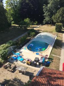 Dammarie-sur-Saulxla maison du parc的享有带椅子和遮阳伞的游泳池的上方景色
