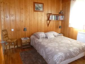夏蒙尼-勃朗峰Chalet * Lioutraz *的一间卧室设有一张床和木墙