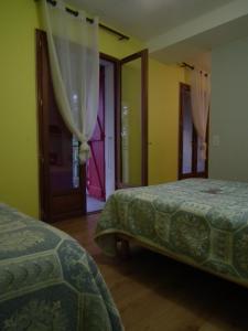 科洛米耶友好旅舍的配有两张床铺的黄色墙壁和窗户