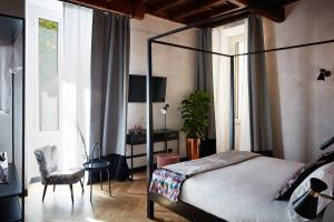 罗马NAMAN HOTELLERIE - Margutta的一间卧室配有一张床、一把椅子和一张书桌