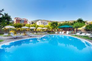 索伦托安蒂奇米拉酒店的一个带椅子和遮阳伞的大型蓝色游泳池