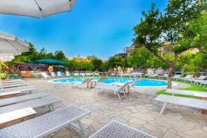 索伦托安蒂奇米拉酒店的一座带白色长椅和桌子的游泳池