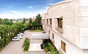 伊斯兰堡Islamabad Regalia Hotel的享有停车场内停放汽车的大楼的正面景色