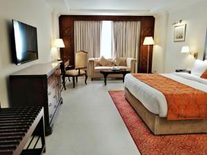 伊斯兰堡Islamabad Regalia Hotel的酒店客房设有床和客厅。