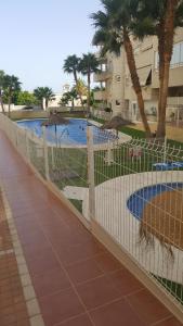 阿瓜杜尔塞A 1 minuto de la playa. Aguadulce ( Almería)的游泳池前的围栏