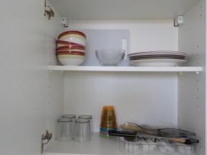 莫雷阿Apartment Studio Halfon的冰箱里装有碗和其他盘子的架子