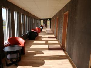 斯卡夫塔费德斯卡夫塔费德酒店的走廊上设有红色椅子、木地板和一排窗户