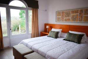 维拉卡洛斯帕兹德尔格提拉波萨达酒店的一间卧室设有一张大床和一个窗户。