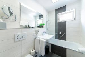 博登斯边的拉多夫采尔斯塔德花园酒店的白色的浴室设有水槽和镜子