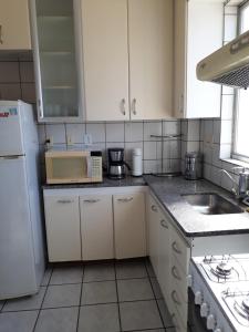 贝洛奥里藏特Apartamento Uberlândia - BH的厨房配有水槽和白色冰箱