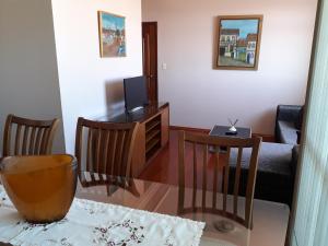 贝洛奥里藏特Apartamento Uberlândia - BH的客厅配有电视和桌椅