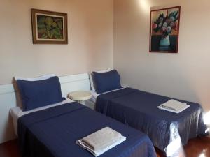贝洛奥里藏特Apartamento Uberlândia - BH的配有蓝色床单的客房内的两张床
