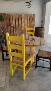 奥比多斯Casa 40th-Music Wood House的一张木桌、椅子和黄色的桌子