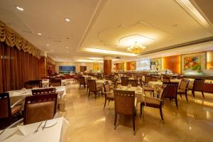 广州嘉逸国际大酒店的一间设有白色桌椅的餐厅和一间酒吧