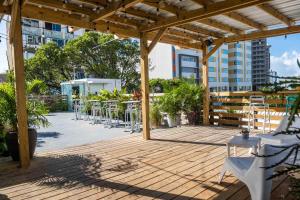 圣胡安Santurcia Hostel的木制甲板上配有桌椅的庭院