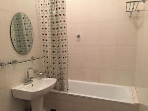 乌兰巴托特索蒙斯服务式公寓的白色的浴室设有水槽、浴缸和镜子