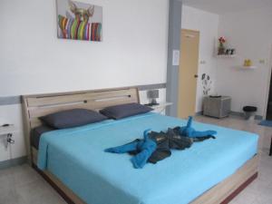 邦涛海滩斯米兰酒店的一间卧室配有一张带蓝色棉被的床