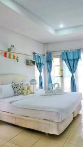 华欣普拉塔纳花园海滩度假酒店的一间卧室配有一张带蓝色窗帘的大床