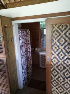 塔巴南Babahan Farmstay的浴室配有淋浴帘和盥洗盆。