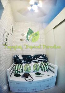 大雅台PS4+NETFLIX+TV PLUS Tagaytay Tropical Staycation at SMDC的一间卧室配有带绿色和白色枕头的床