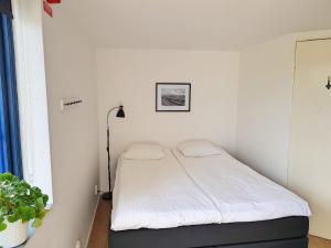 斯塔德Gårdshotellet的一间小卧室,配有白色床单