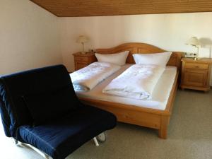 福森Ferienwohnung Doris Strodl的一间卧室配有一张木床和椅子
