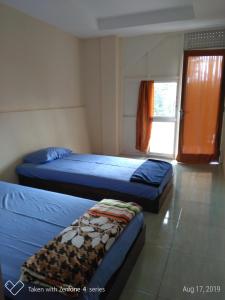 沃诺索博Rumah Sakinah的一间卧室设有两张床和窗户。