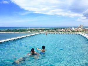 洞海CKC乐园酒店的两人在大型游泳池游泳
