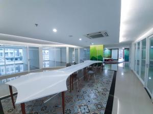 斯勒曼Apartemen Taman Melati Sinduadi By NGINAP的办公室,配有长白的桌子和椅子