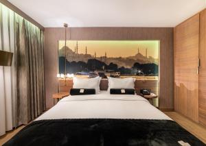伊斯坦布尔Hotel Saint Sophia的卧室配有一张大床,墙上挂有绘画作品