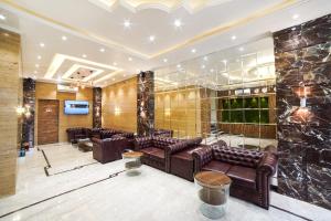 纳威孟买Hotel Radana Vashi Navimumbai的大堂设有棕色皮革沙发和石墙
