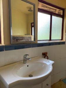 金贾Samuka Island Retreat的浴室设有白色水槽和镜子