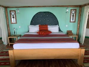 金贾Samuka Island Retreat的一间卧室配有一张大床和大床头板