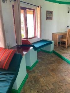 金贾Samuka Island Retreat的客厅设有2张长椅和桌子
