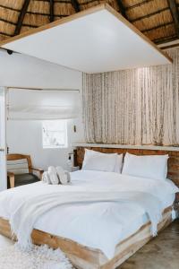 Rev EstatesQambathi Mountain Lodge的卧室配有白色大床和白色枕头