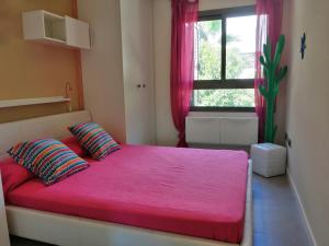 阿瓜阿马加CASA LA ROCA的一间卧室配有粉红色的床、两个枕头和窗户
