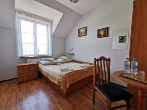 克拉科夫Hotel TERESITA的卧室配有1张床、1张桌子和1把椅子