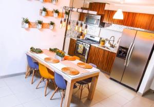 提华纳Boho Condominium and Unique Comfort in Tijuana的厨房配有桌椅和冰箱。