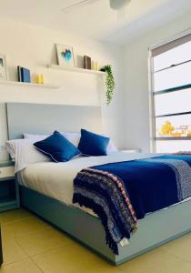 提华纳Boho Condominium and Unique Comfort in Tijuana的一间卧室配有一张带蓝色枕头的大床