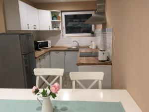 蒂萨凯奇凯Tisza Dream Apartman的厨房配有白色橱柜和粉红色鲜花桌