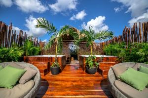 图卢姆Grand Balam Plaza的庭院设有2张桌子和椅子,种植了棕榈树。