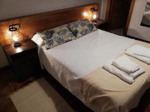利亚内斯LA ALDEA的卧室配有带两盏灯的白色床