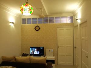 亚依淡Fastbook Bendera Home 8 & 10pax的带沙发和电视的客厅