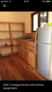 锡基霍尔Hillside Village apartment 72sqm size with kitchen的厨房配有白色冰箱和木制橱柜。