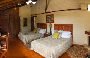 塔巴贝拉卡萨德坎波塔巴贝拉精品酒店的一间卧室设有两张床和一个壁炉