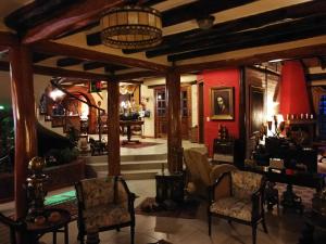 塔巴贝拉卡萨德坎波塔巴贝拉精品酒店的客厅配有椅子、桌子和红色墙壁