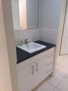 玛丽伯勒Waratah and Wattle Apartments的浴室设有白色水槽和镜子