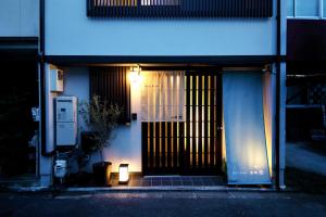 京都Guest House Nishijin Yui的建筑物的前门,晚上有灯