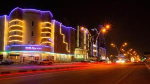 阿可贺巴Rona Al Khobar Hotel的夜幕,建筑和街灯