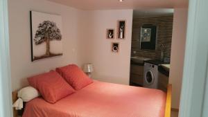LuzenacLes 3 marguerites的一间卧室配有带橙色床单的床和一间浴室